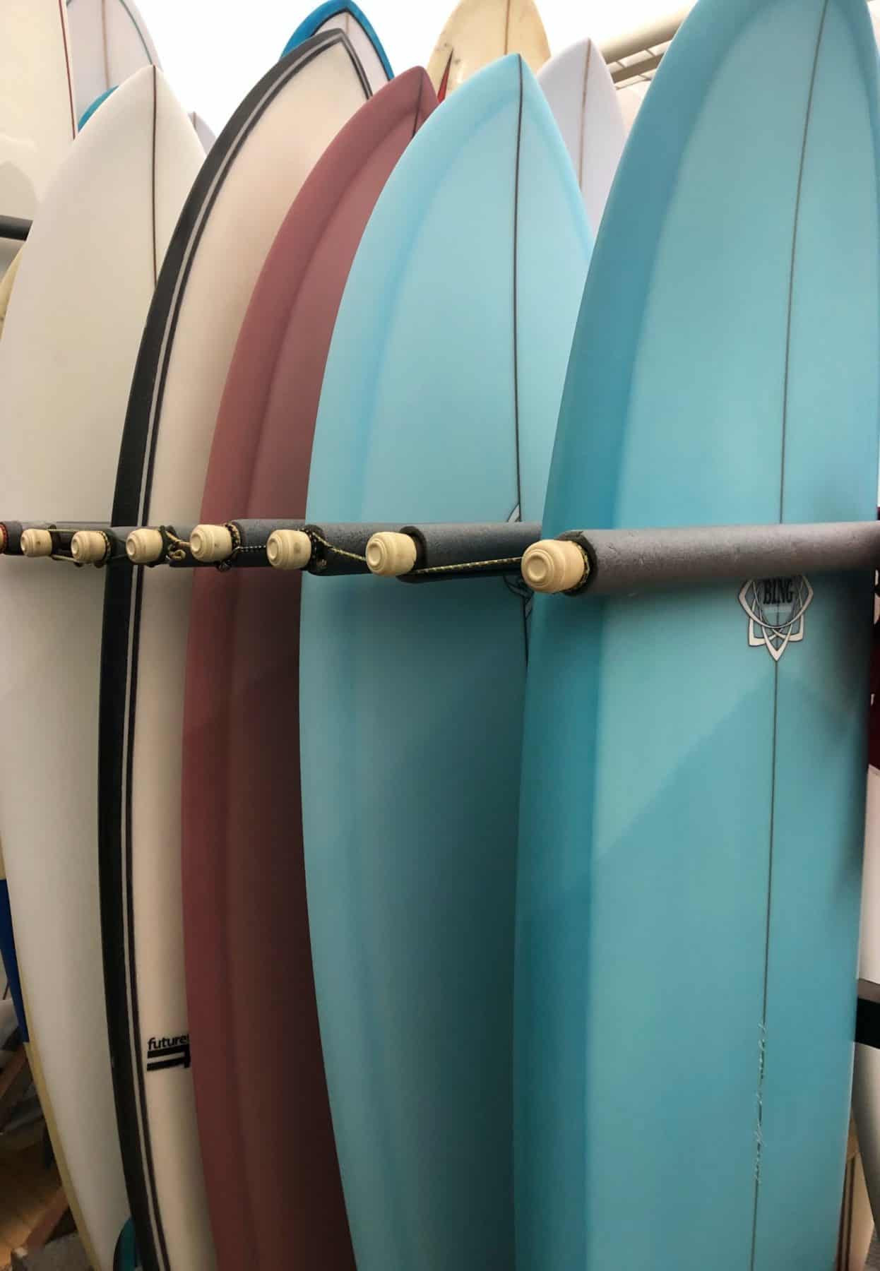 A group of surfboards are lined up in a row.