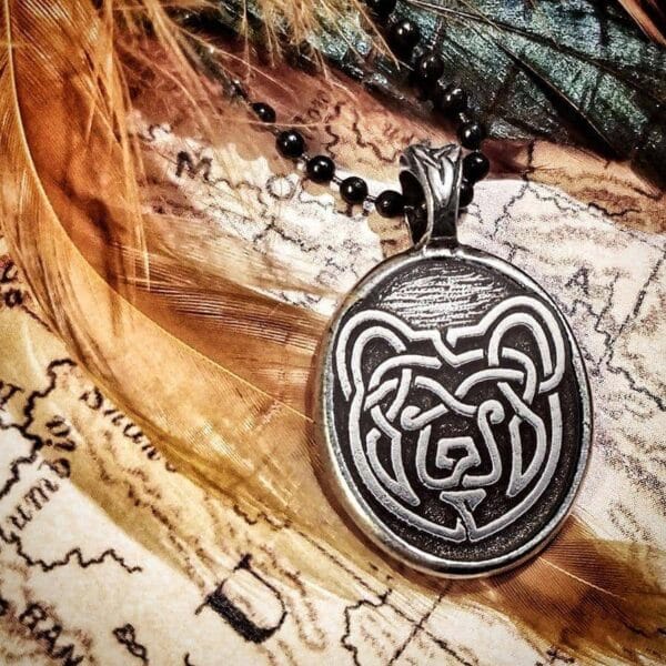 A pendant with an image of a bear sitting on top of a map.
