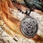A pendant with an image of a bear sitting on top of a map.