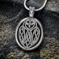 A silver pendant with an owl on it.