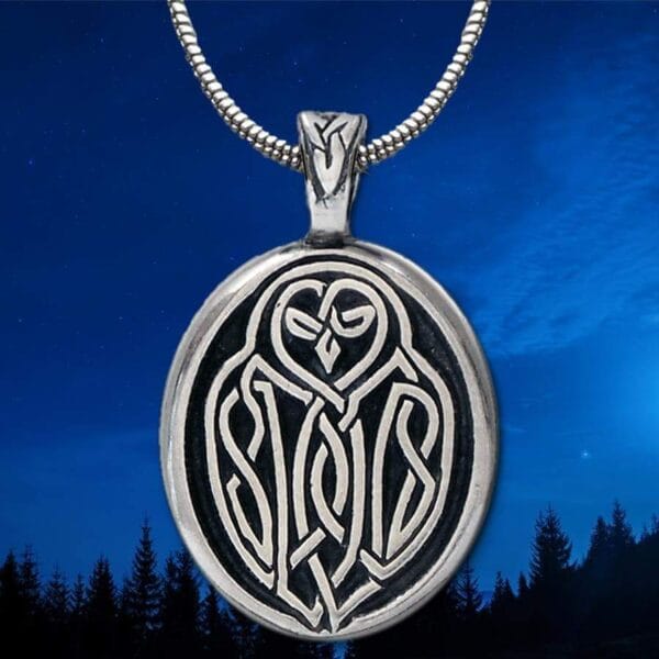 An owl pendant with a moon in the background.