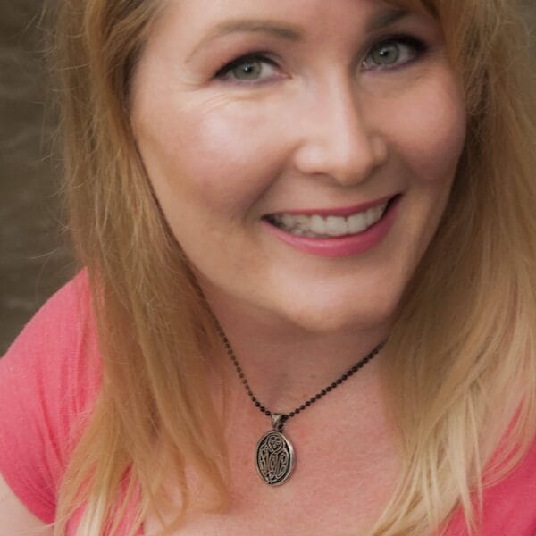 A woman smiling with a necklace on her neck.