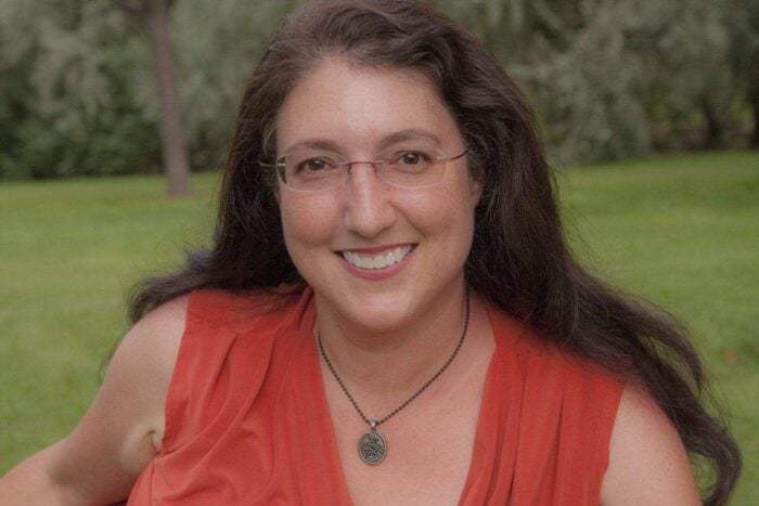 A woman in a red top is smiling in a field. A woman in a red top is smiling in a field.