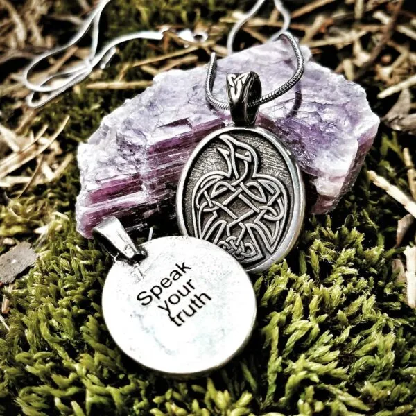 A pendant with the words speak your faith on it.