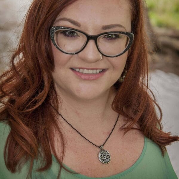 A woman wearing glasses and a necklace.