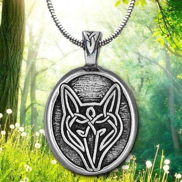The celtic wolf pendant is shown in the woods.