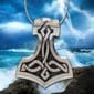 A thor hammer pendant with a lightning bolt on it.