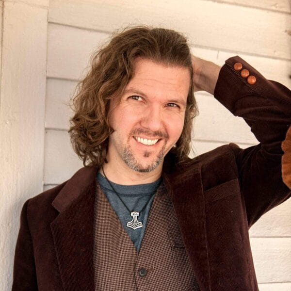 A man with long hair is posing for a photo.