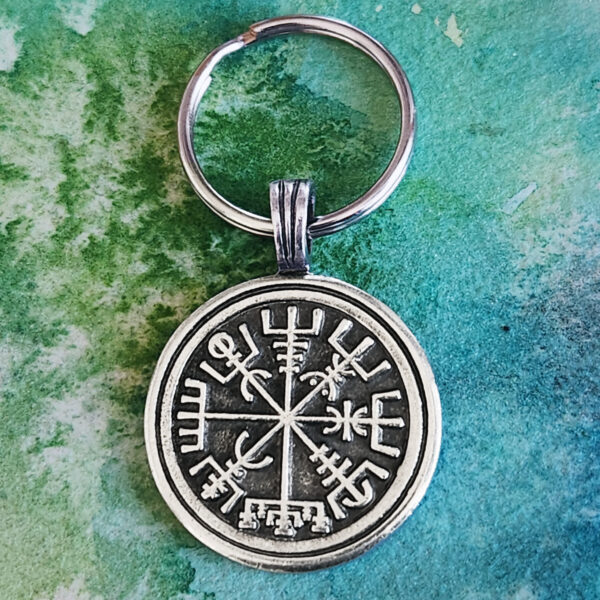A keychain with a viking symbol on it.