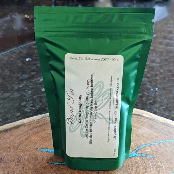 A bag of green tea sitting on top of a wooden cutting board.