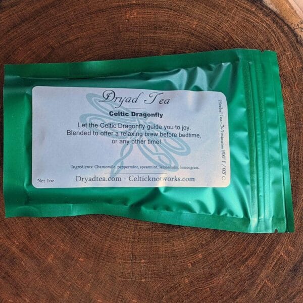 A bag of green tea sitting on top of a piece of wood.
