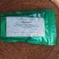 A bag of green tea sitting on top of a piece of wood.