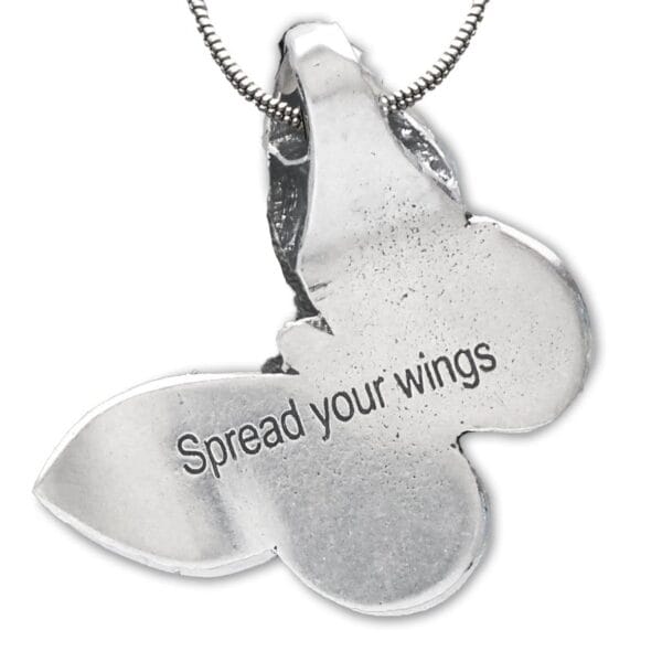 A silver butterfly pendant with the words spread your wings.