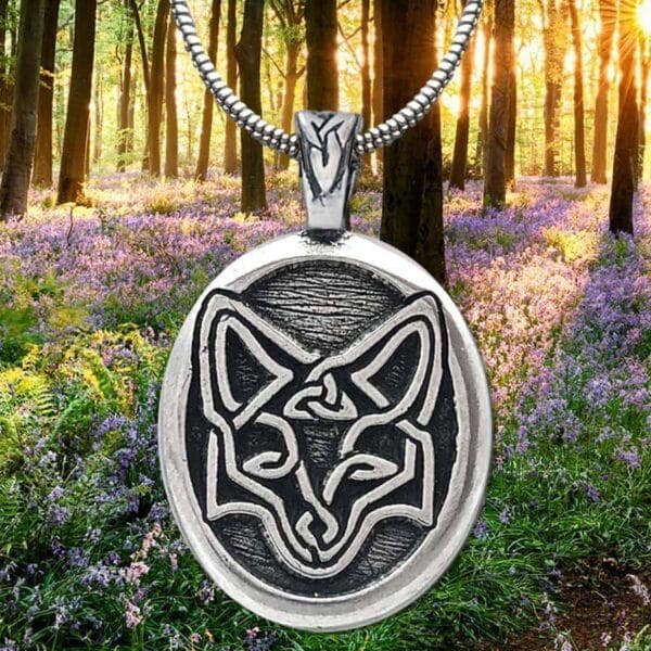 A pendant with a fox on it in the woods.