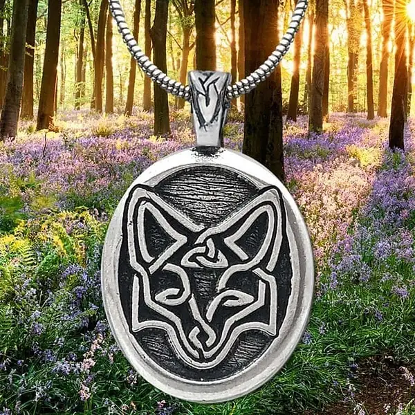 A pendant with a fox on it in the woods.
