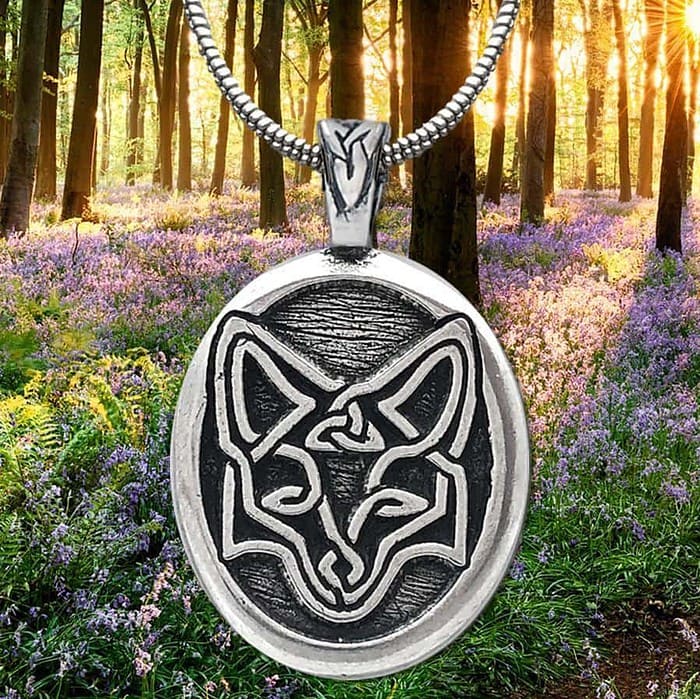 A pendant with a fox on it in the woods.