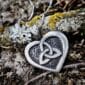 A heart shaped pendant with moss on it.