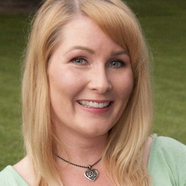 A woman in a green shirt holding a frisbee.