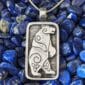 A silver pendant with a polar bear on it.