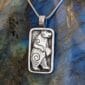 A silver pendant with a polar bear on it.