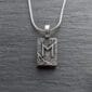 A sterling silver necklace with the letter m on it.