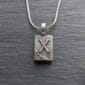 A silver necklace with a celtic cross on it.