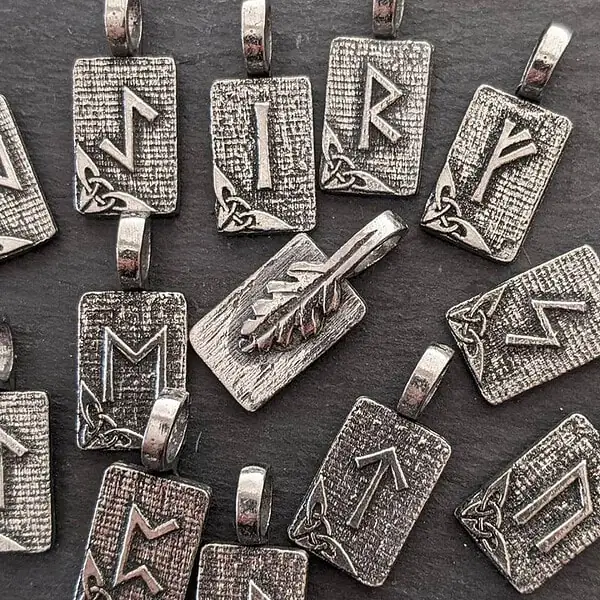 A group of sterling silver pendants with arrows on them.