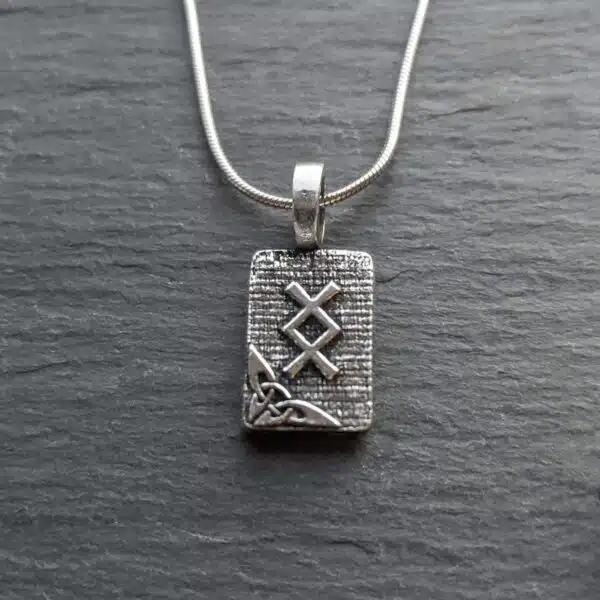 A silver necklace with a celtic symbol on it.