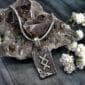 A silver necklace with a viking symbol on it.