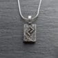 A silver necklace with a celtic symbol on it.