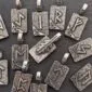 A group of sterling silver pendants with arrows on them.