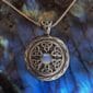 A celtic pendant with a moonstone on it.