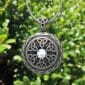 A silver celtic pendant with a moonstone on it.