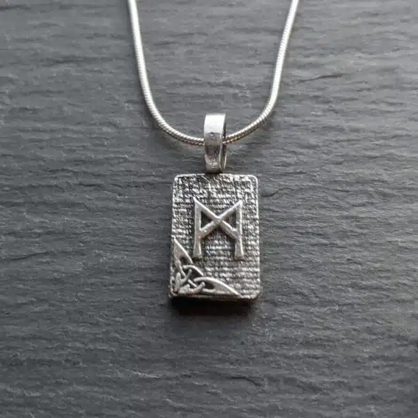 A silver pendant with a celtic design on it. A silver pendant with a celtic design on it.