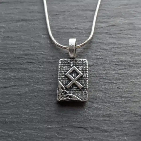 A silver necklace with a viking symbol on it.