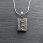 A silver necklace with a viking symbol on it.