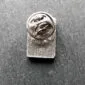 A silver lapel pin on a table.