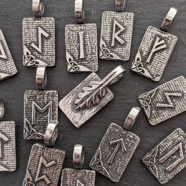 A group of sterling silver pendants with letters on them.