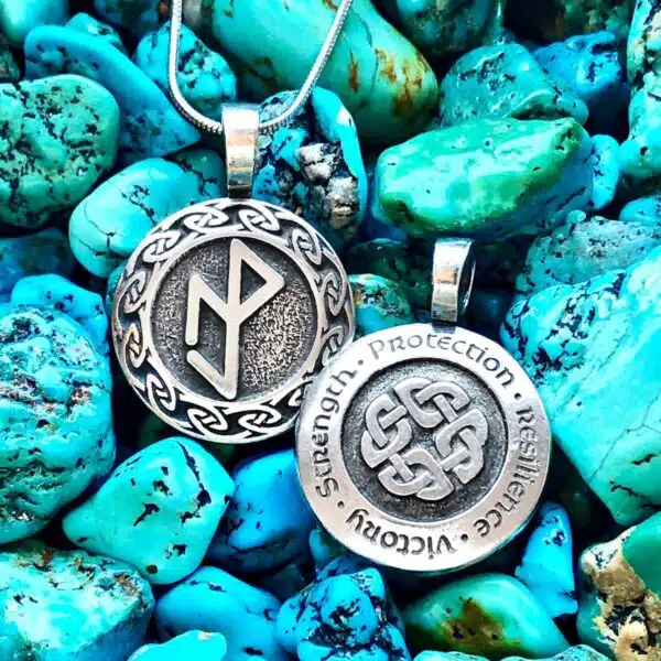 Two silver pendants with a celtic symbol on them.