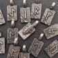 A group of sterling silver pendants with letters and arrows on them.
