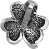 A silver plated clover charm on a gray background.