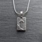 A silver necklace with an arrow on it.