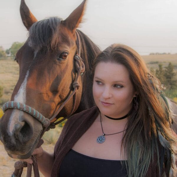 A woman standing next to a horse.