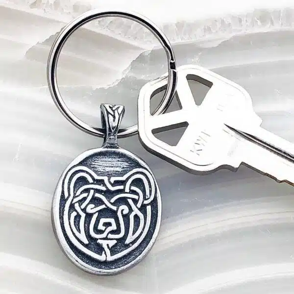 A silver keychain with a bear on it.