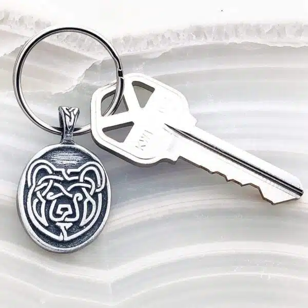 A silver keychain with a bear on it. A silver keychain with a bear on it.