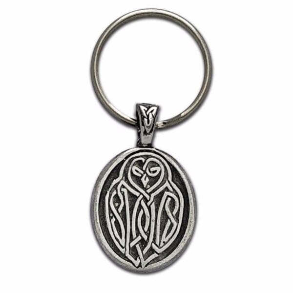 An owl keychain with a celtic design on it.