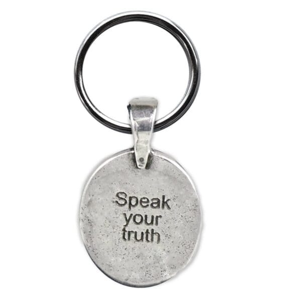 A silver keychain that says speak your truth.