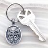 A silver keychain with a fox on it.