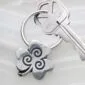 A silver key chain with a shamrock on it.