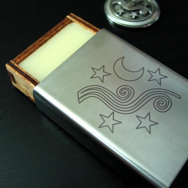 A silver soap box with a moon and stars on it.